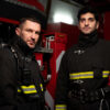 Two firefighters in full gear standing inside a fire station, representing first responders affected by low testosterone in Hackensack NJ.