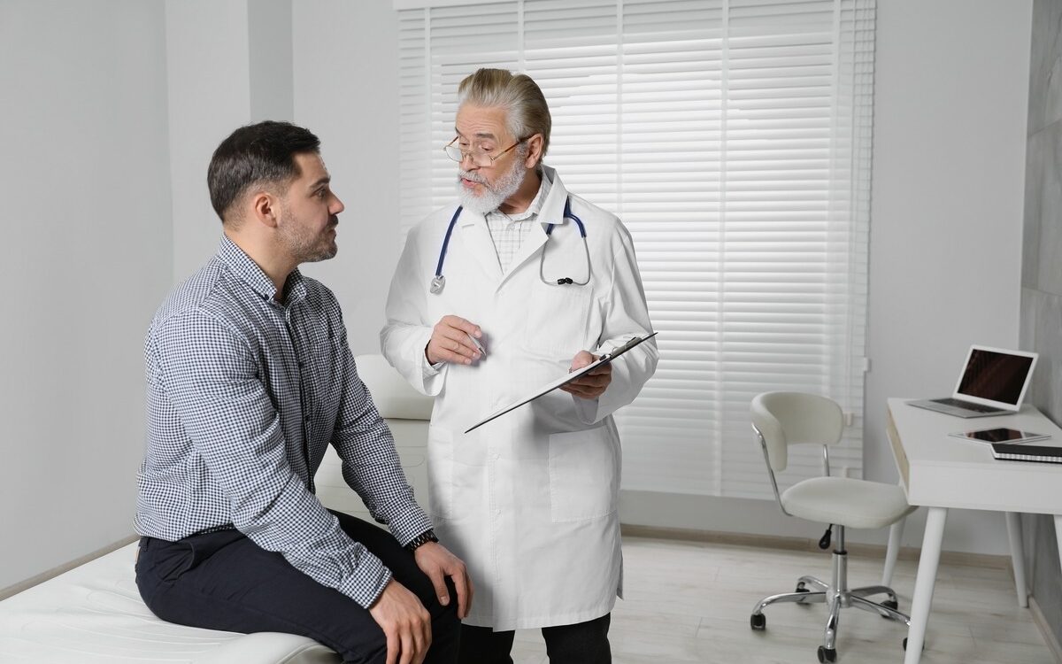 Man discussing testosterone replacement therapy with healthcare provider during consultation