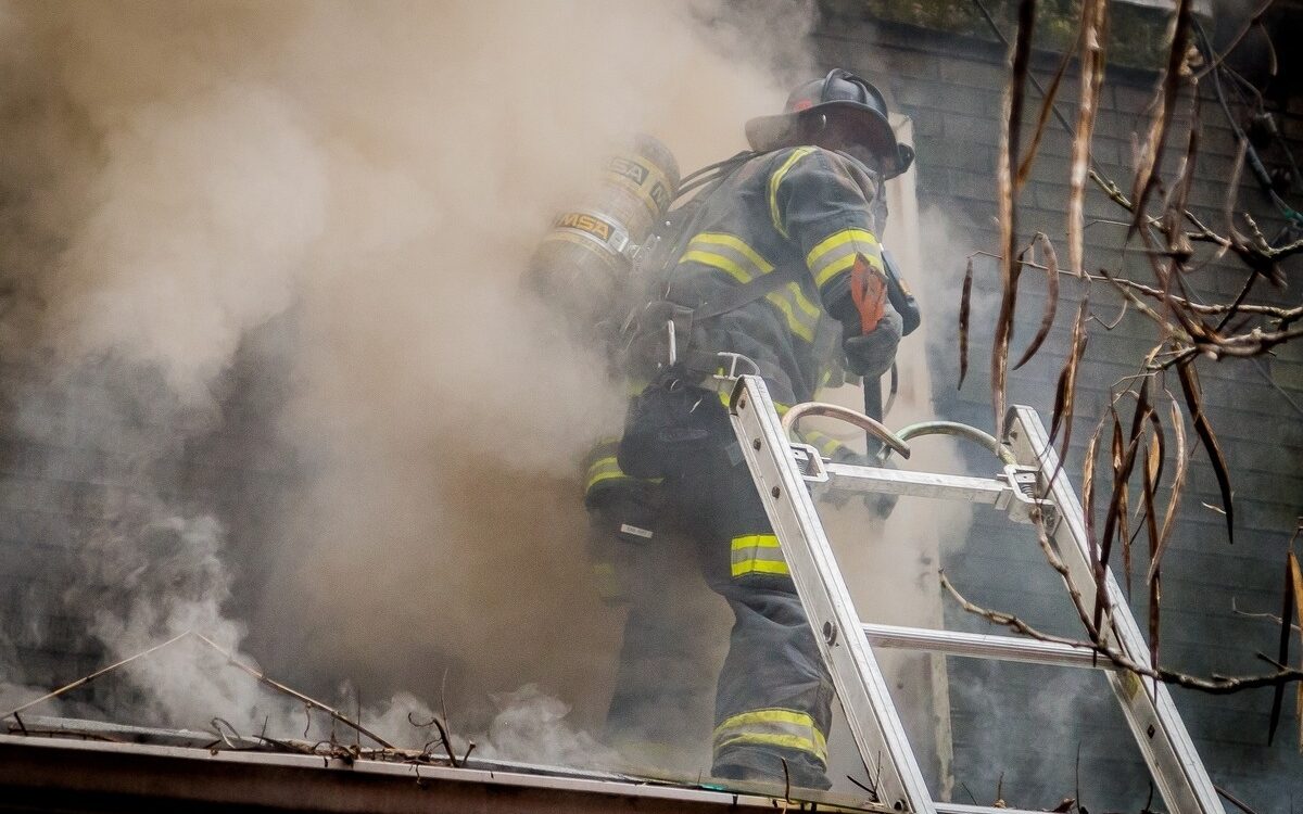 firefighter smoke exposure during active structural fire response climbing ladder into burning building