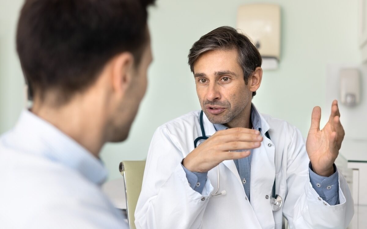 TRT timeline consultation showing physician explaining testosterone replacement therapy results to male patient