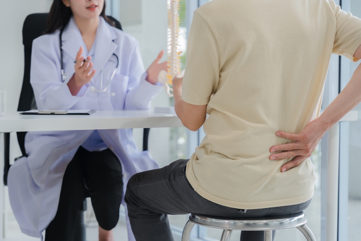Doctor explaining spine anatomy to a patient with lower back pain during a pain management in Hackensack consultation